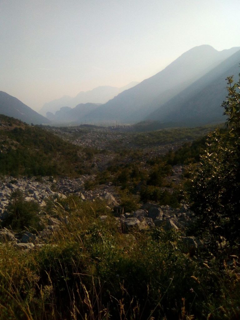 Le Marocche di Dro, una frana provocata dal ritiro dei ghiacciai. Il Lago di Garda è poco dopo i rilievi più bassi sullo sfondo.